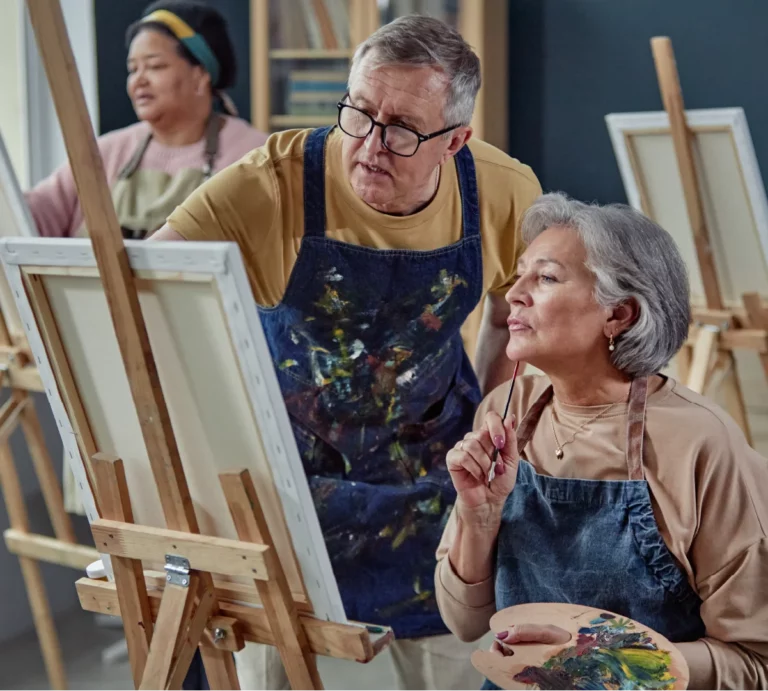 An elderly couple painting together