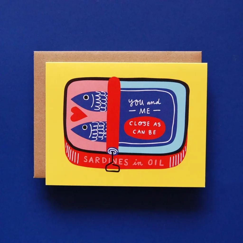 A yellow, red, and blue illustrated notecard depicting canned sardines with text that reads, "You and me close as can be" and "Sardines in oil."