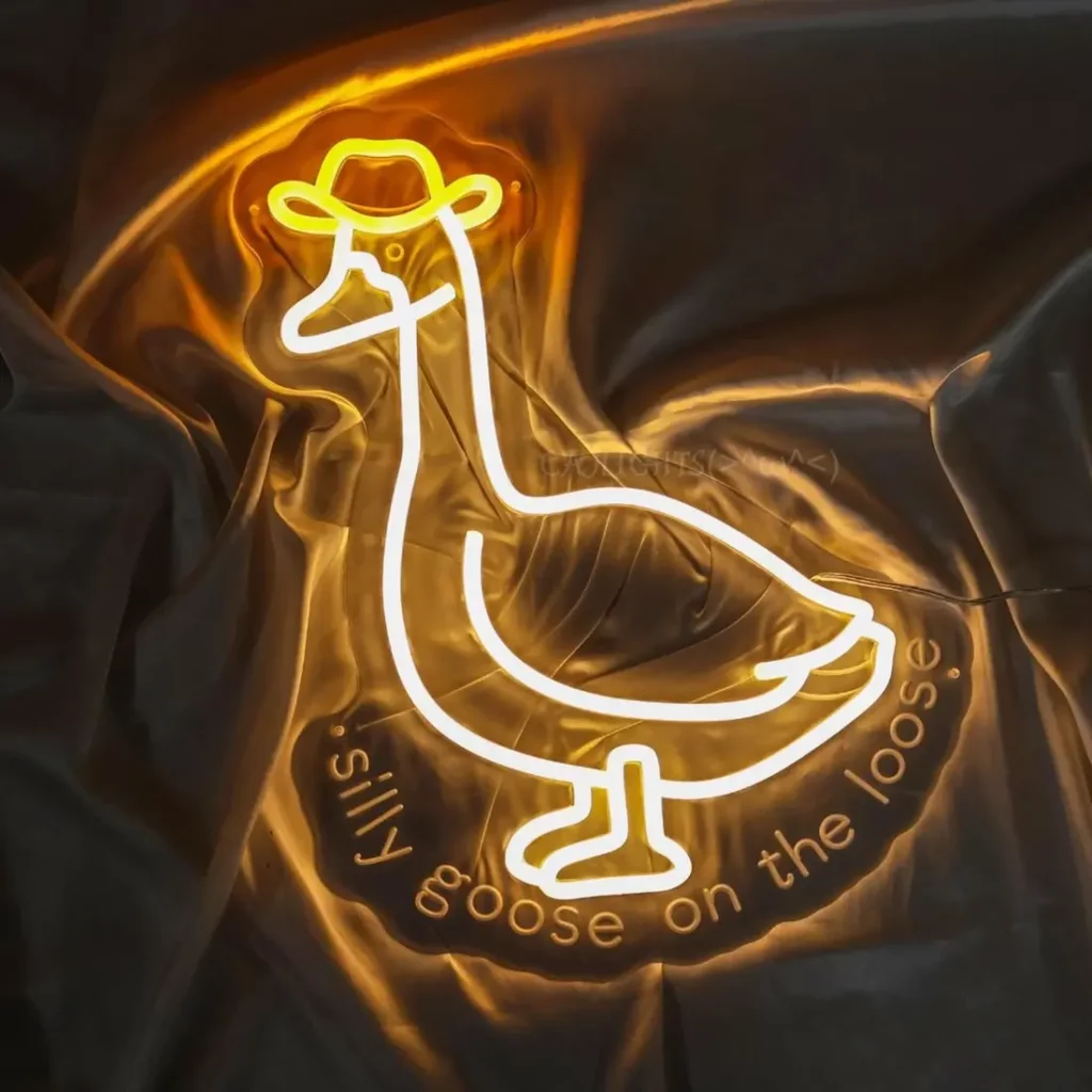 A yellow and white neon LED sign depicting a goose wearing a cowboy hat with text that reads, "silly goose on the loose."